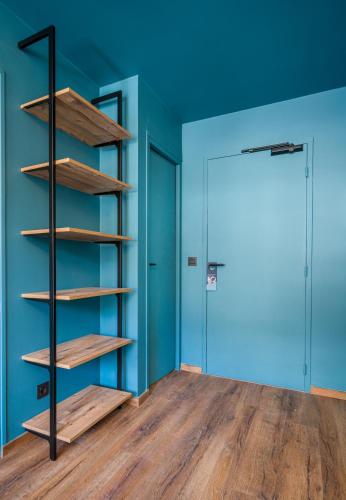 an empty room with wooden shelves and a blue wall at L'Outa Hotel Restaurant in Termignon