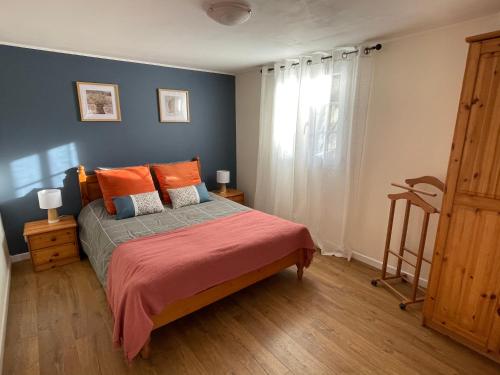 um quarto com uma cama com almofadas laranja e uma janela em Netmust vacances em Saint-Palais-sur-Mer