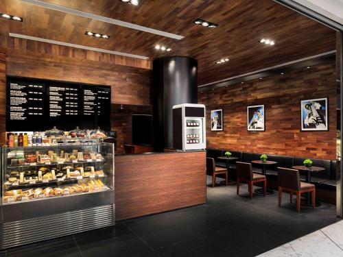 a bakery with a counter and some tables and chairs at Novotel Citygate Hong Kong in Hong Kong