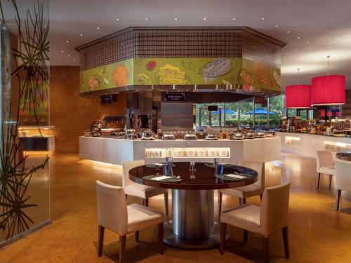 a restaurant with a table and chairs and a bar at Novotel Citygate Hong Kong in Hong Kong