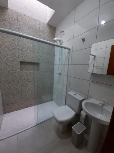 a bathroom with a toilet and a shower and a sink at Casa férias Itapoá in Itapoa