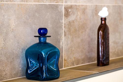 a blue glass bottle sitting on a counter next to a brown bottle at L'Outa Hotel Restaurant in Termignon