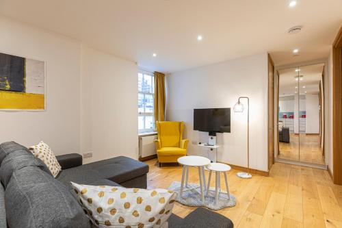 een woonkamer met een bank en een tafel bij Marylebone Apartments in Londen