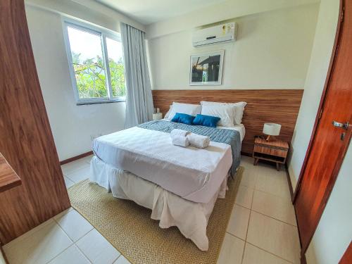 a bedroom with a bed with blue pillows on it at Tree Bies Resort - Oficial in Subaúma