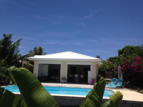 a villa with a swimming pool and a house at Chambre d'hôte Coeur-CoCo piscine in Saint-François