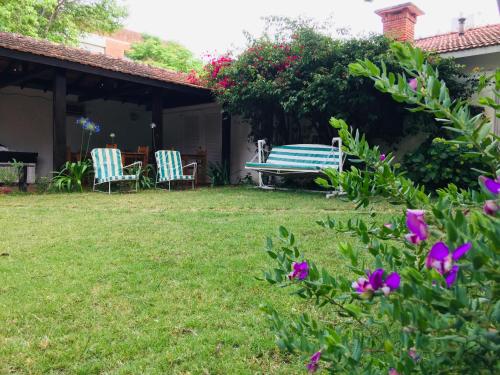 un patio con un banco, sillas y flores en San Remo Punta Hotel, en Punta del Este