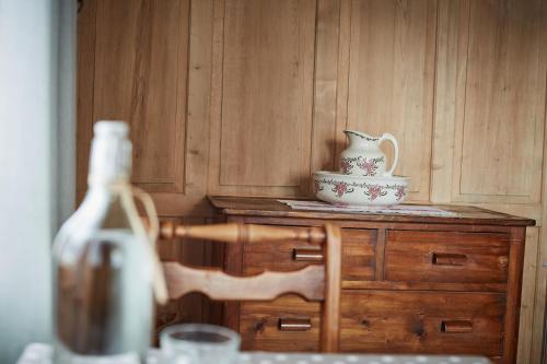 a table with a vase on top of a wooden cabinet at Nostalgie Bed & Breakfast Chrämerhus in Curaglia