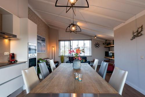 a kitchen and dining room with a wooden table and chairs at Ostreahof Gezin & Familie vakantiehuis aan strand en jachthaven in Kamperland