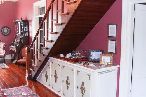 a staircase in a living room with red walls at Flowertown Bed and Breakfast in Summerville