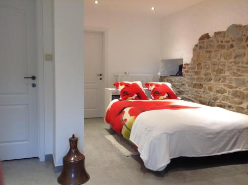 a bedroom with a large bed with red pillows at Gite Evasion in Aywaille