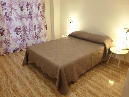 sypialnia z łóżkiem i stołem z lampką w obiekcie Apartamento Guardamar Playa w mieście Guardamar del Segura