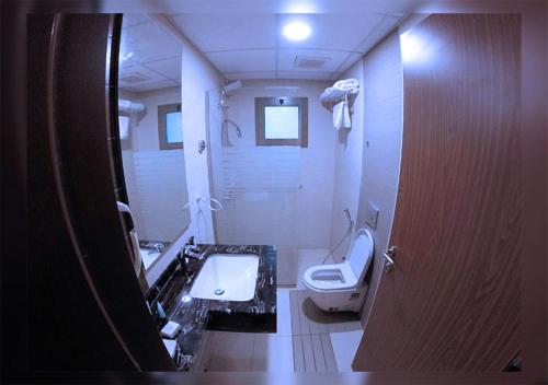 a bathroom with a toilet and a sink and a mirror at روائع الأحلام للاجنحة الفندقية in Jeddah