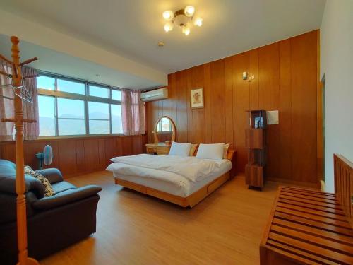 a bedroom with a bed and a couch in it at 樸宿庭園民宿 南投民宿312號 in Lugu
