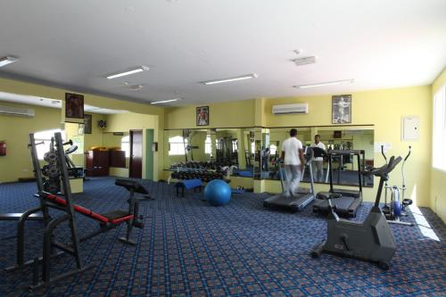 Ein Mann in einem Fitnessstudio mit Gewichten und Trainingsgeräten. in der Unterkunft Ramee Dream Resort in Seeb