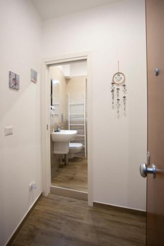 a bathroom with a sink and a toilet and a clock at B&B LA CHICCA in Bari