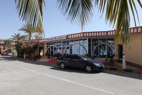 a black car parked in front of a building at Ramee Dream Resort in Seeb