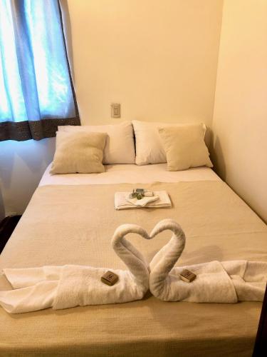 two towels in the shape of a heart on a bed at Papitos Bacalar Hotel and Marina in Bacalar