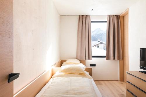 two beds in a hotel room with a window at The one and only in Serfaus