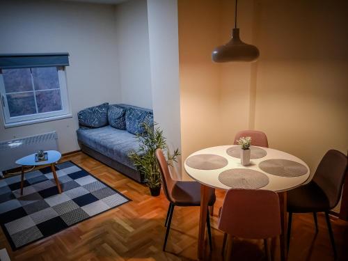 ein Wohnzimmer mit einem Tisch und einem Sofa in der Unterkunft STAR apartman Brzece Kopaonik in Brzeće