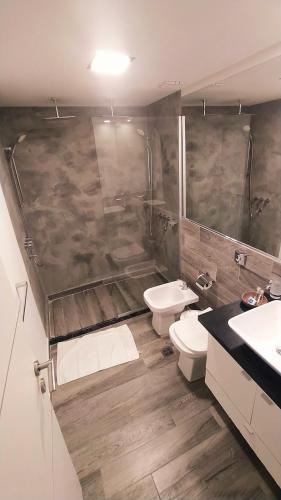 a bathroom with two sinks and a toilet and a shower at Domus Lake Resorts in Villa Carlos Paz