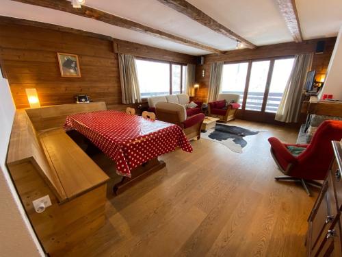 a living room with a table and chairs and windows at Hurlebise 8 in Verbier