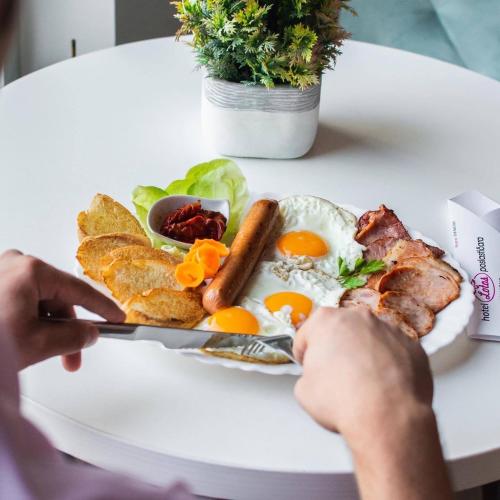 a plate of breakfast food with eggs and bacon at Garni Hotel Lotos in Niš