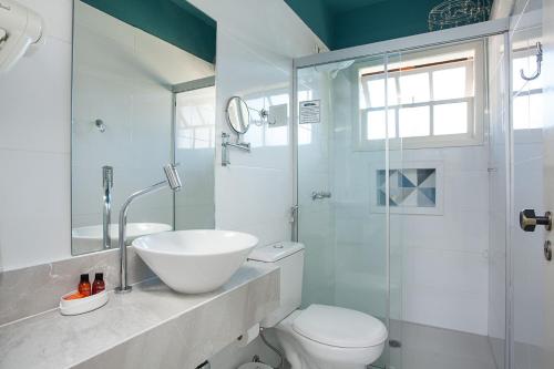 a bathroom with a sink and a toilet and a shower at Pousada Camburioca in Camburi