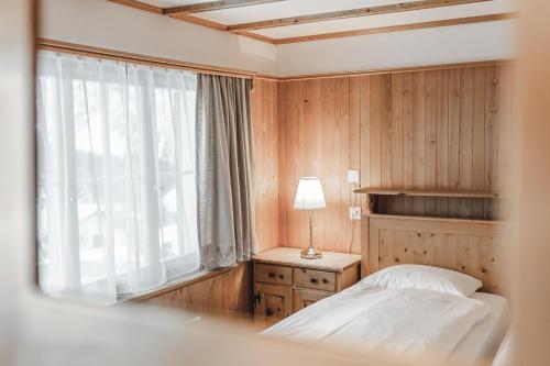 a bedroom with a bed and a window at Chalet Sunna Höckli - Pistennah und Ruhig mit Panoramablick in Arosa