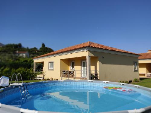 a large swimming pool in front of a house at Casa das Bocelinhas in Arouca
