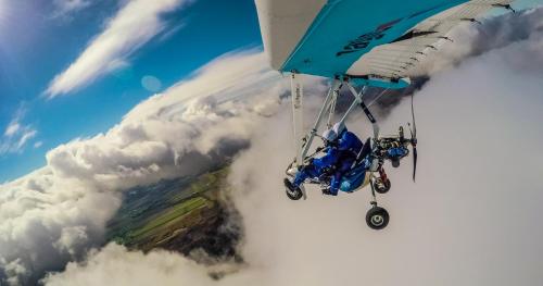 a person is hanging from a plane in the clouds at Days Inn by Wyndham Berthierville in Berthierville