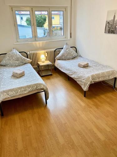 Duas camas num quarto com piso em madeira em Gemütliches WG-Zimmer 5, zentral in Ravensburg (stadtnah) em Ravensburg