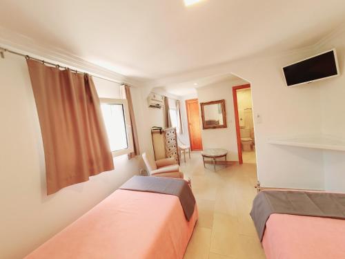 Habitación con 2 camas y sala de estar. en Hotel Maritimo, en Alicante