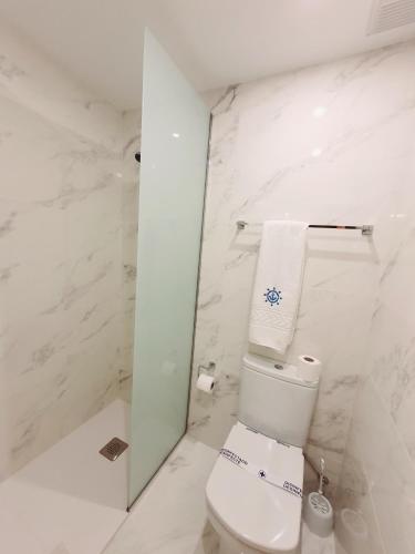 a white bathroom with a toilet and a mirror at Hotel Marítimo Urban in Alicante