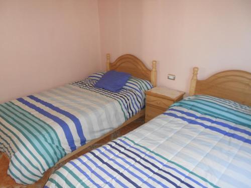 two beds sitting next to each other in a bedroom at Cabañas Las Palmeras Pichilemu in Pichilemu