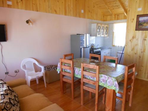 a kitchen and dining room with a table and chairs at Cabañas Las Palmeras Pichilemu in Pichilemu