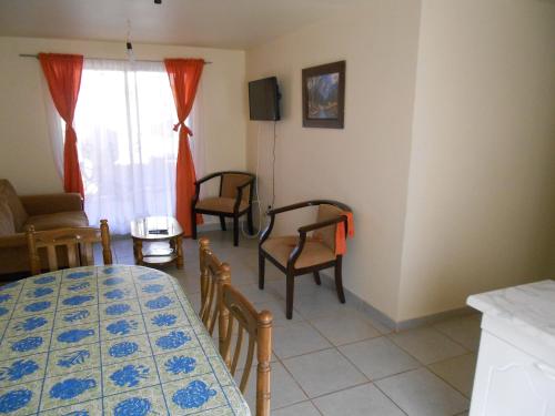 a living room with a table and chairs in a room at Cabañas Las Palmeras Pichilemu in Pichilemu