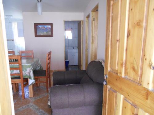 a living room with a couch and a table at Cabañas Las Palmeras Pichilemu in Pichilemu