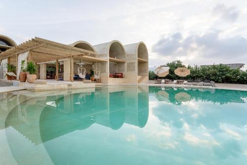 a swimming pool with blue water in front of a house at Casona Sforza in Puerto Escondido