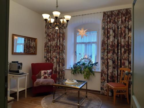ein Wohnzimmer mit einem Stuhl, einem Tisch und einem Fenster in der Unterkunft K5-Suites in der Altstadt Annaberg-Buchholz in Annaberg-Buchholz