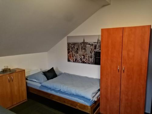 Schlafzimmer mit einem Bett und einem Holzschrank in der Unterkunft Penzion U Jana in Výprachtice