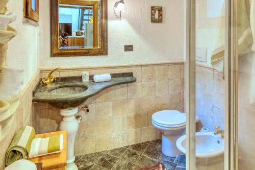 La salle de bains est pourvue d'un lavabo, de toilettes et d'un miroir. dans l'établissement MARIO Apartment with Garden, à Levanto