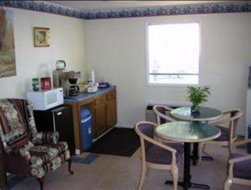 a living room with a table and chairs and a window at America's Best Value Inn - Loudon in Loudon