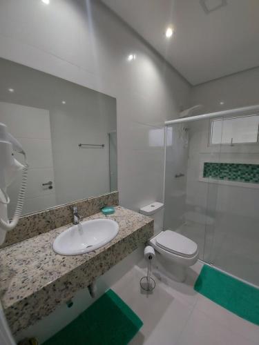 a bathroom with a sink and a toilet at Hospedagem Jardins de Gramado in Gramado