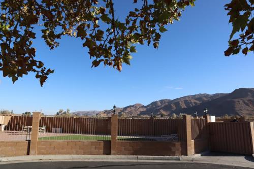 a fence with mountains in the background at Oasis Inn & Suites 29 Palms Hotel Joshua Tree National Park in Twentynine Palms
