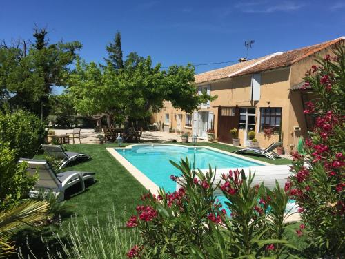 a swimming pool in a yard next to a building at Mas 19e climatisé avec piscine à usage exclusif in Roquemaure