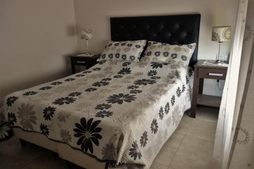 1 dormitorio con 1 cama con edredón blanco y negro en Balcones De La Riviera en Córdoba