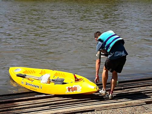 a man standing next to a yellow kayak on a dock at La Verdosa in Tigre