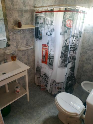 a bathroom with a toilet and a shower curtain at Departamentos Arco Iris Tandil in Tandil