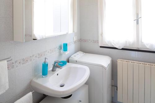 een badkamer met een wastafel, een toilet en een spiegel bij RAFFAELLA House in Levanto
