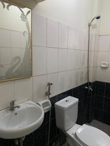 a bathroom with a toilet and a sink at Perlies Inn Tanay Barkada House in Tanay